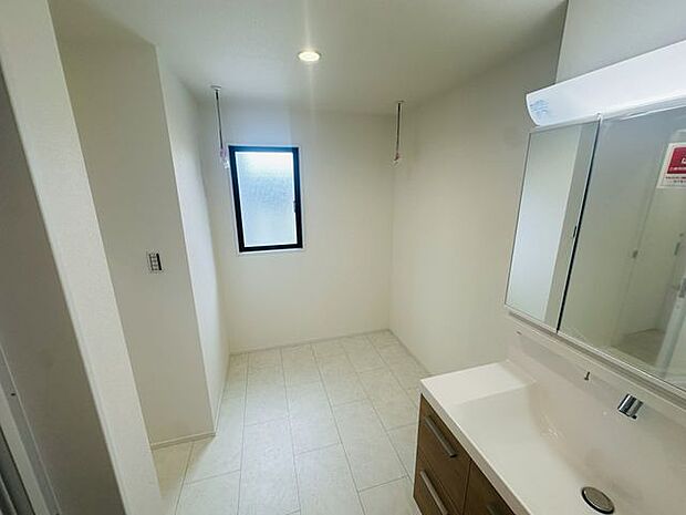 【洗面室】室内物干しが設置された洗面室。窓があり自然換気が行えます。※家具調度品等は販売価格に含まれません。