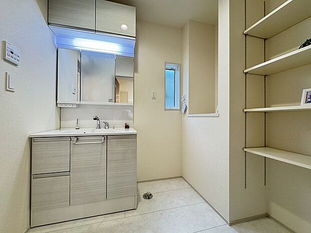 【洗面室/施工例】洗剤やタオルなどの収納に便利なカウンターと可動棚が備わっています。※実際とは異なる場合があります。