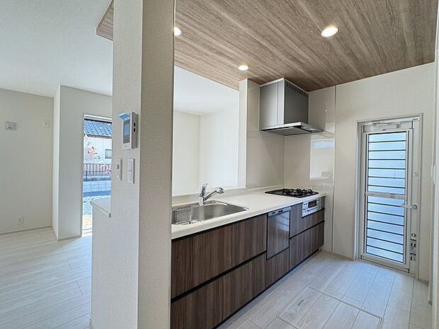 【キッチン/5号棟】LDKと統一感のあるシステムキッチン!木目調の落ち着いたデザインが採用されています。