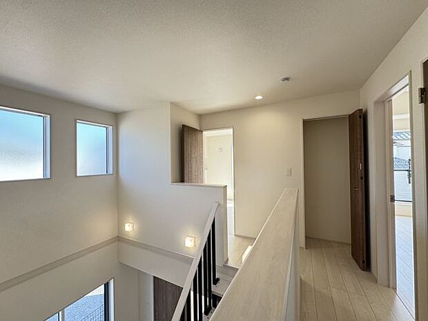 【2階ホール/5号棟】吹抜部分にも窓が配されており、2階部分も明るい設計です。2階の各洋室は振り分けタイプで、プライベートタイムを大切にできる間取りです。