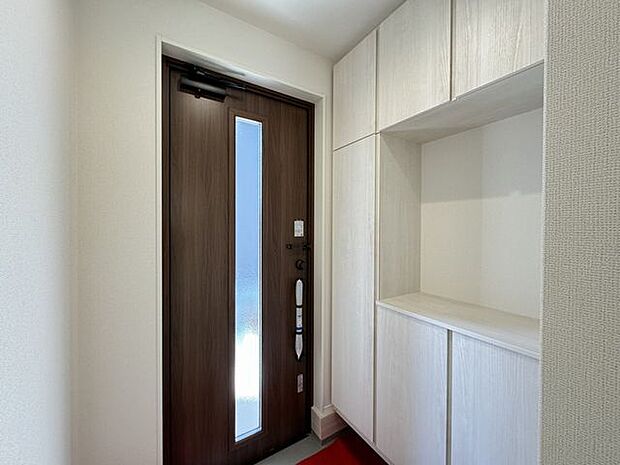 【玄関/施工例】玄関にはカウンター付きの下駄箱が設置されています。鍵や郵便などの一時置きに便利です。※実際とは異なる場合があります。