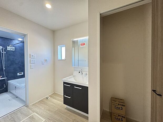 【洗面所/2号棟】洗面所に設置された収納スペースは、ご家族の着替えやタオル、掃除用品などをしまうのに便利。