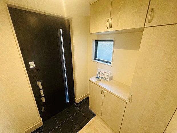 【玄関】ドアのスリット部分や小窓から光が届く、明るい玄関です。シューズボックス付きで、ご家族の履物をスッキリと片付けられます。※家具調度品は販売価格に含まれません。