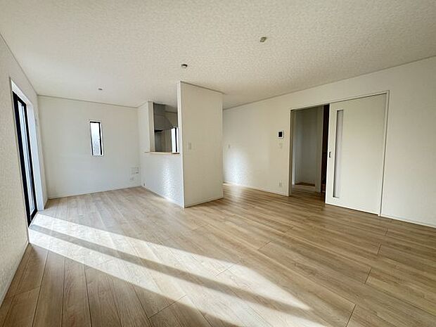 【LDK/2号棟】LDKは約17.5帖。家具などを置いてもゆとりのある広さです。お互いの顔を見ながら会話ができる対面仕様のシステムキッチンが採用されています。