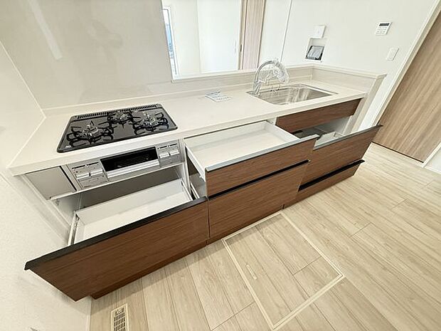 【キッチン】グリル付きの三口ガスコンロが搭載されたシステムキッチン。下部の収納は使い勝手の良いスライド式です。