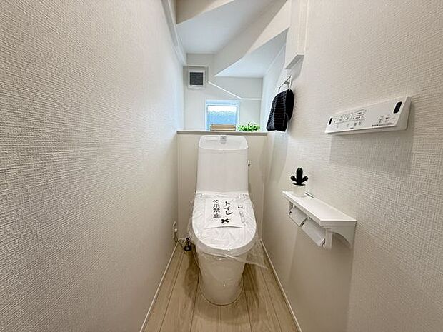【トイレ/1階】温水洗浄便座付きのトイレです。寒い時期でも暖かな便座で快適に使うことができます。リモコンが壁に設置され、操作しやすい仕様です。※家具調度品等は販売価格に含まれません。