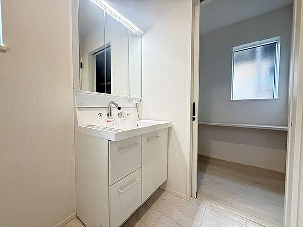 【洗面所/1号棟】洗面所近くにフリースペースが設けられています。引き戸タイプなので出入りがしやすくなっています。