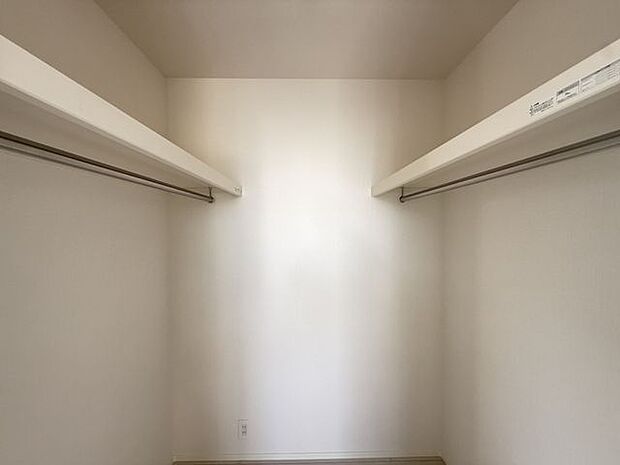 【ウォークインクローゼット/1号棟】両側にハンガーパイプと収納棚が備わっているので、衣類や小物をたくさん収納できます。