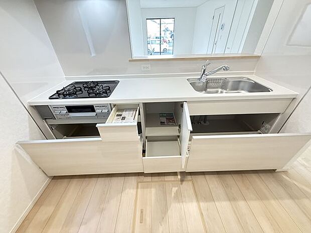 【キッチン/1号棟】立ったまま使えて、奥の物も出し入れしやすいスライドタイプの収納が備わったキッチンです。