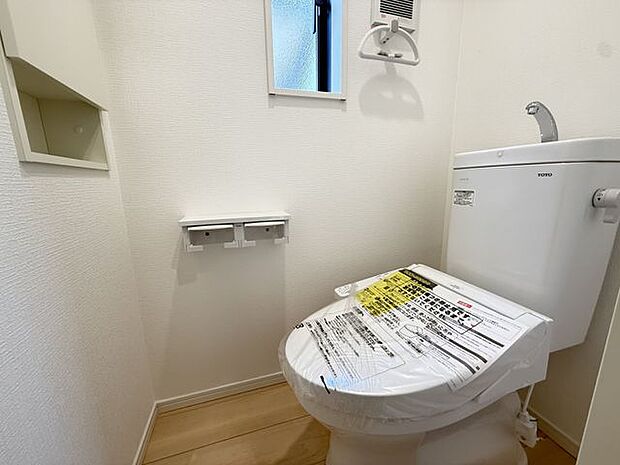 【2階トイレ/3号棟】トイレットペーパーのストックや掃除用品などをしまえる収納スペースが設置されています。
