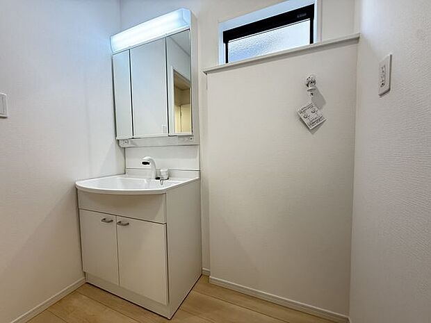 【洗面室/3号棟】朝の身支度もスムーズに行える三面鏡仕様の洗面化粧台。鏡裏や洗面ボウル下部に収納スペースが設けられています。