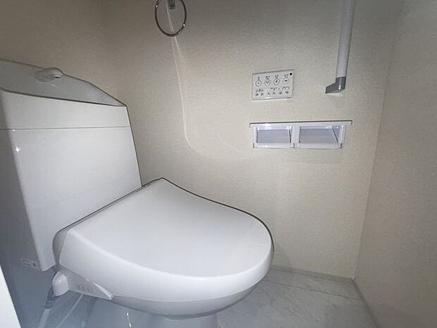 【1階トイレ/1号棟】温水洗浄便座が備わり、寒い時期でも快適に使用できます。操作しやすい壁面リモコンが採用されています。