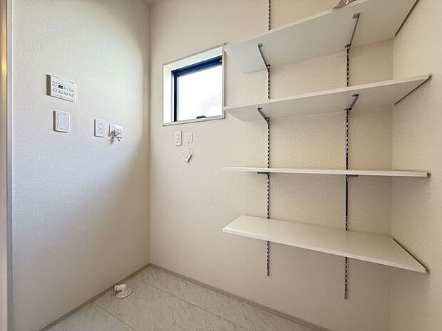 【ランドリールーム/1号棟】洗濯用品やタオルなどの収納に便利な可動棚が備わっています。