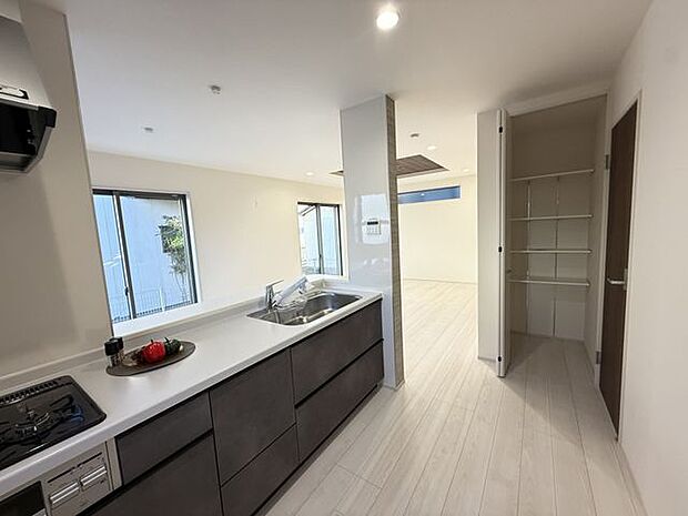 【キッチン】買い物からの帰宅時に、玄関から洗面所を通る回遊動線が便利です。そのまま収納庫へ収納できます。