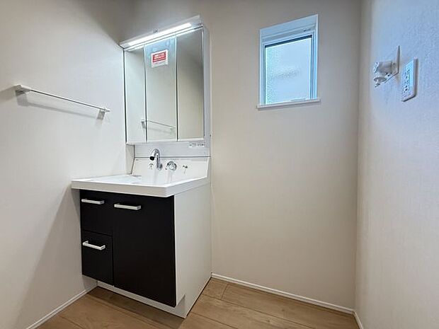 【洗面室/1号棟】身支度がしやすい三面鏡付きの洗面化粧台が採用されています。小窓が設けられているので、採光と自然換気が叶います。