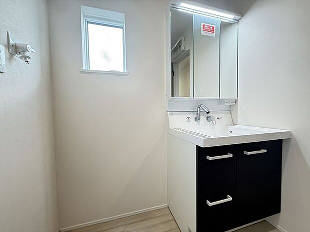 【洗面室/2号棟】身支度がしやすい三面鏡付きの洗面化粧台が採用されています。小窓が設けられているので、採光と自然換気が叶います。