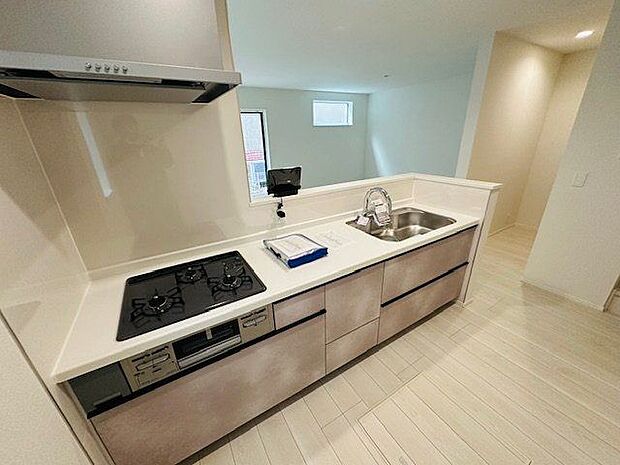 【キッチン/1号棟】コンロやシンクの周りにはキッチンパネルが施され、油や水はねのお手入れがスムーズ。キッチン前面に腰壁が施され、手元が見えにくい仕様です。