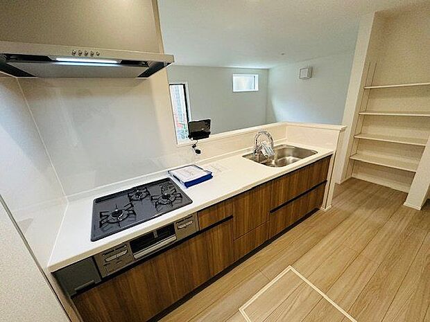 【キッチン/2号棟】コンロやシンクの周りにはキッチンパネルが施され、油や水はねのお手入れがスムーズ。キッチン前面に腰壁が施され、手元が見えにくい仕様です。