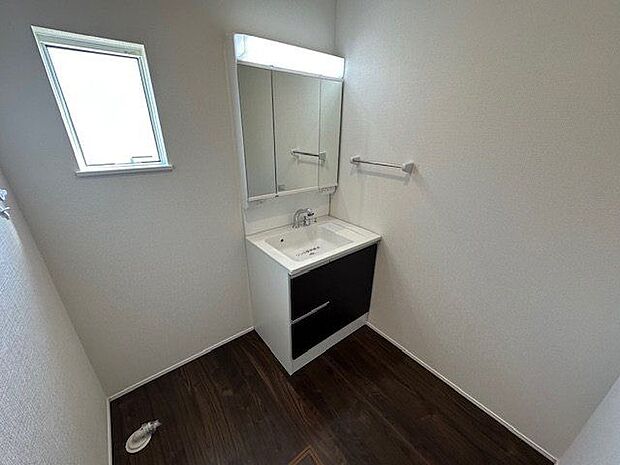 【洗面室/3号棟】洗面室には洗面化粧台と室内洗濯機置き場を設けています。フリースペースから直接出入りできる動線を確保しており、家事を効率的に行える間取りを採用しています。