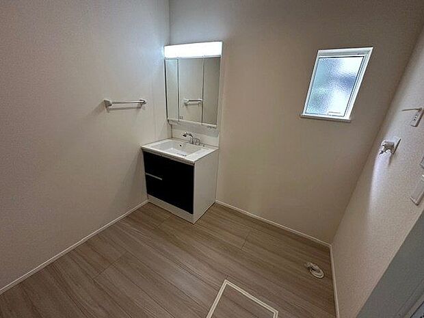 【洗面室】窓があり自然光が注ぎ込む明るい洗面室です。身支度の際に重宝する三面鏡タイプの洗面台が設けられています。