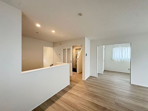 【LDK/A号棟】隣接する洋室(約5.0帖)の引き戸を開放すると、続き間として活用できます。室内に心地の良い光と風が通ります。