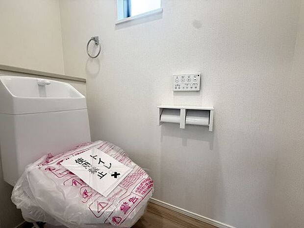 【トイレ/1階/1号棟】温水洗浄便座付きのトイレです。背面のカウンターは、予備のペーパー置場などに活用できます。窓があるため、自然換気が可能です。