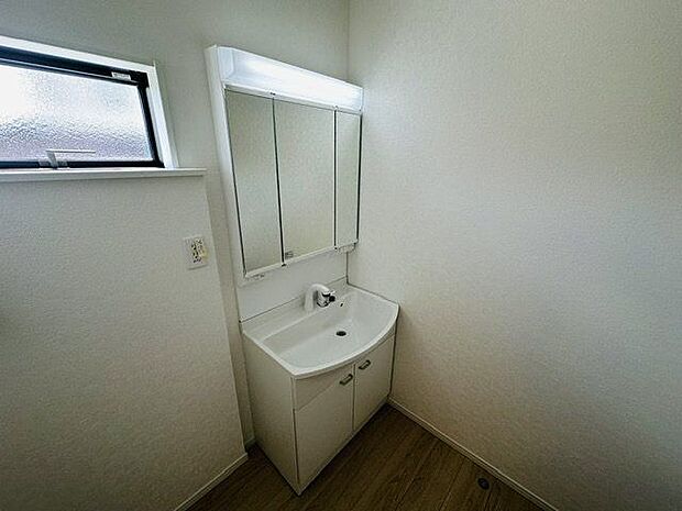 【洗面室】窓から自然光が入る洗面室。洗濯機置場が設けられています。ホワイトを基調とした、清潔感のある空間です。