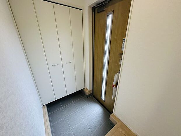 【玄関】ドアのスリット部分から自然光が差し込む、明るい玄関です。