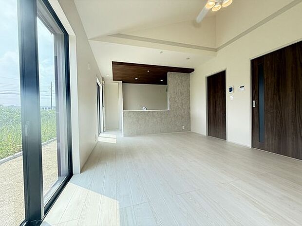 【LDK/5号棟】空間に広がりを感じさせる勾配天井が採用されています。明るくシンプルな内装なので、お好みのインテリアで空間づくりを楽しめます。