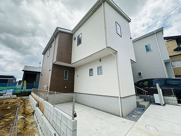 【外観/2号棟】ツートンカラーが採用された、飽きの来ないシンプルな外観デザインです。木目調デザインの外壁がアクセントに。