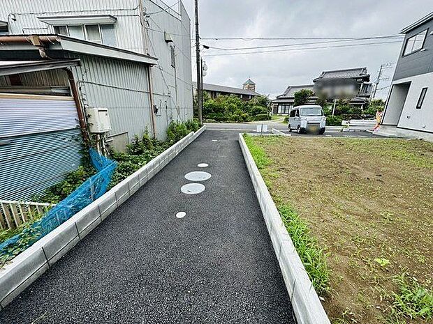 【前面道路含む現地写真】建物から道路に続くアプローチはアスファルトで舗装されています。