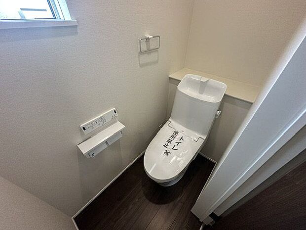 【トイレ(1階)/1号棟】落ち着いた印象と清潔感のあるトイレです。棚には、トイレットペーパーなどの備品や芳香剤などを置くことができます。