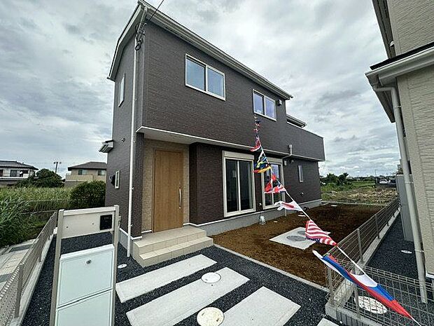 【現地外観写真/1号棟】シックな色味がおしゃれな外観です。玄関ポーチには屋根がついているので、雨でも濡れずにお出かけ準備が出来ます。