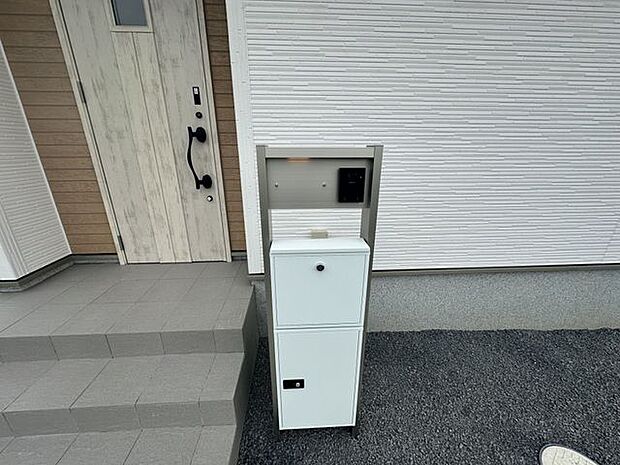 【玄関/4号棟】温かみのある木目調の玄関ドアが採用されています。宅配BOXが備わっており、不在時も荷物を受け取ることが可能です。