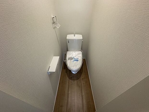 【2階トイレ/4号棟】各階にトイレが備わり、来客時に重宝します。ペーパーホルダー上の棚には、小物や香りアイテムを飾って楽しめます。