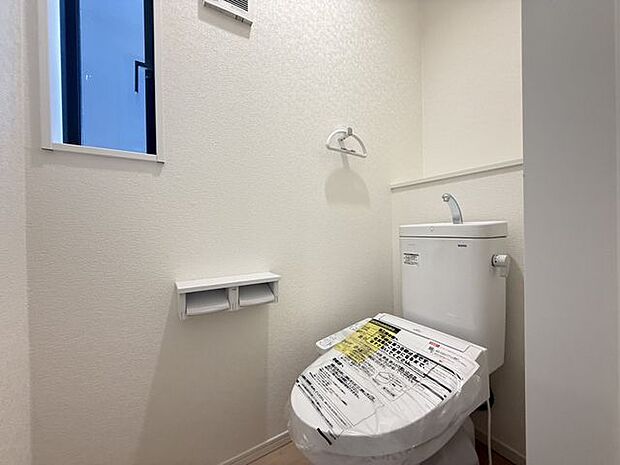 【トイレ/1階】一年中快適に使用できる、温水洗浄便座付きのトイレです。棚には小物や芳香剤などを置くことができます。