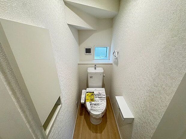 【トイレ(1階)/4号棟】トイレには扉付きの収納があり、お掃除の道具などもすっきりと収納可能。自然換気が行える小窓付きです。