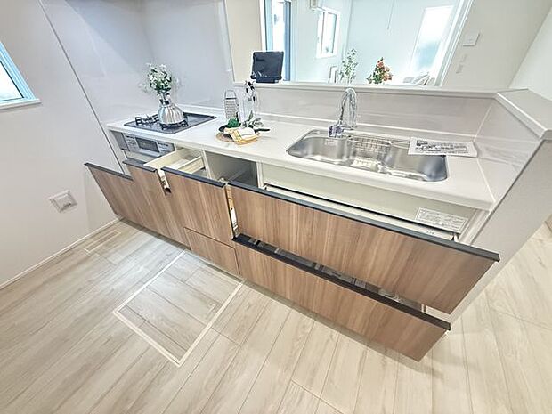 【キッチン/2号棟】キッチン足元に備えられた床下収納は、保存食や備蓄品、調理器具などをすっきりと仕舞える便利なスペースです。※家具調度品は販売価格に含まれません。