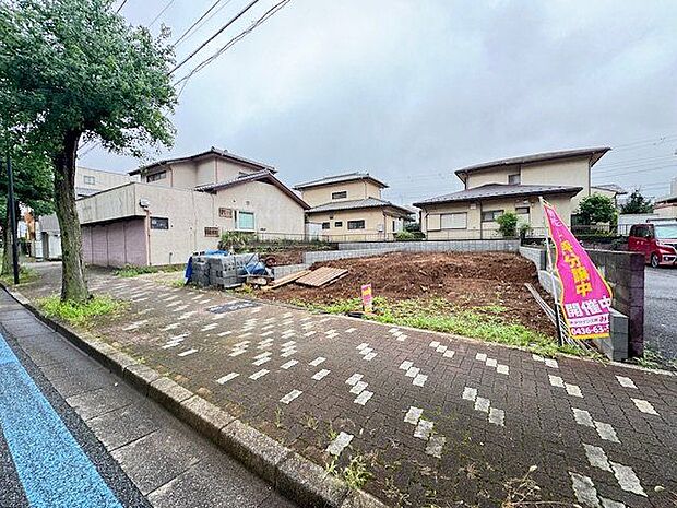 【現地外観写真/1号棟】前面道路は北側です。幅員約22mの道路には中央分離帯が整備され、街路樹のある歩道が設けられています。