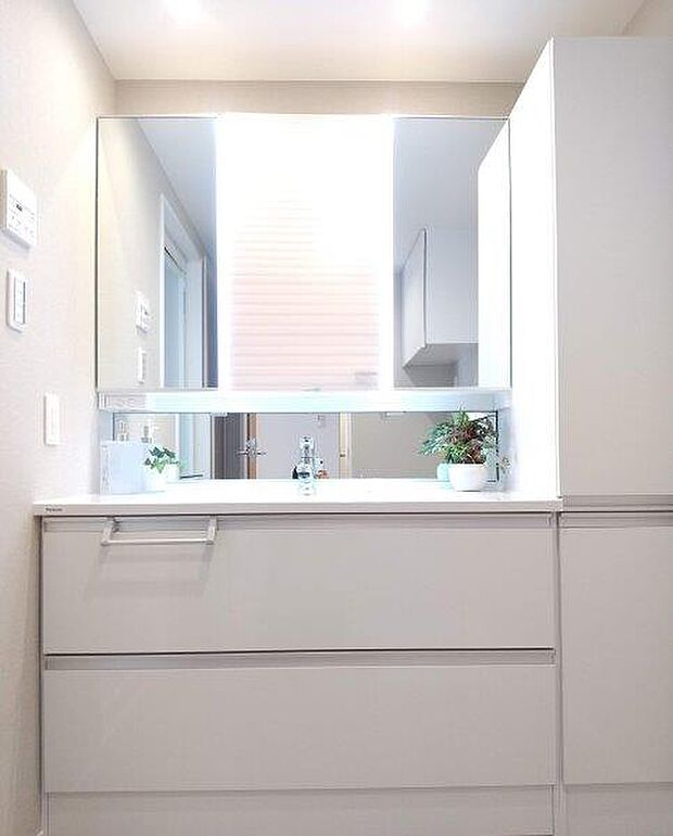白を基調とした清潔感のあるパウダールーム。大き目の隠し棚がありタオルや日用品を収納できます。 