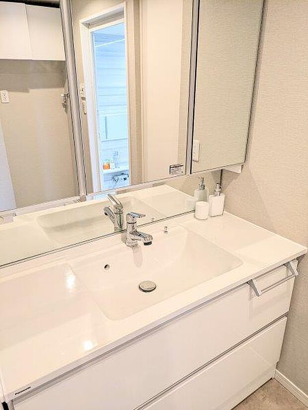 白を基調とした清潔感のあるパウダールームです。鏡裏には歯ブラシや化粧品も収納できます。 