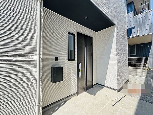 ポーチのついた新築分譲物件。玄関の印象はいかがでしょうか?入口からご覧ください。