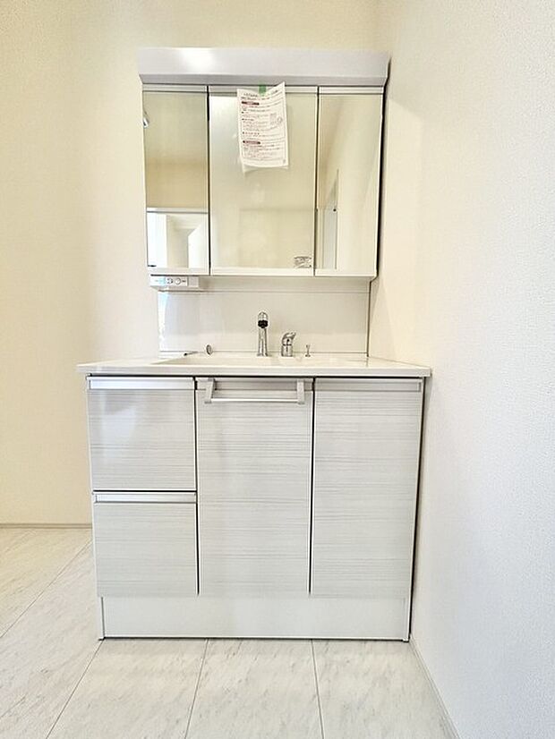 ワイドなボウルにハンドシャワー水栓が付いた洗面化粧台。 