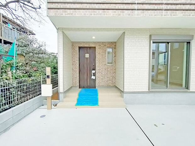 ポーチのついた新築分譲物件。玄関の印象はいかがでしょうか？入口からご覧ください。 