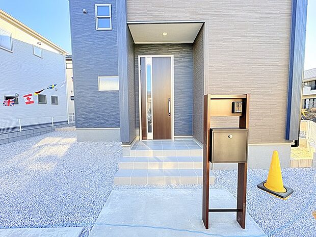 玄関ドアをあけてすぐの場所に配置された機能門柱。ポスト、表札、照明が一点に集中しています。