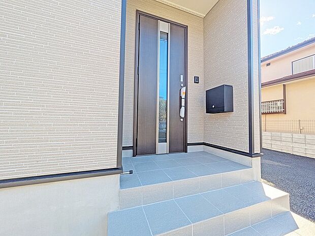 ポーチのついた新築分譲物件。玄関の印象はいかがでしょうか？入口からご覧ください。