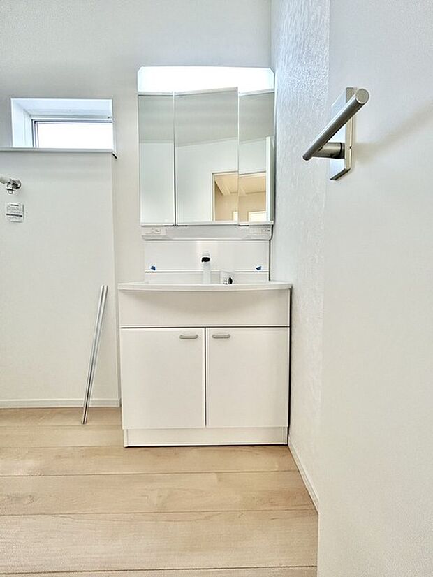 ワイドなボウルにハンドシャワー水栓が付いた洗面化粧台。 