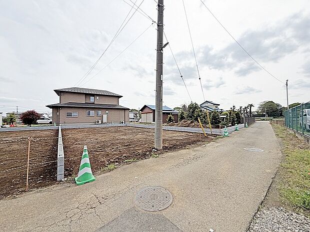 穏やかな空の下、整えられた土地と住まいが静かな佇まいを見せています。広がる空と、ゆったりと続く道の先に、新しい暮らしの舞台が始まります