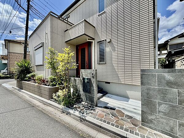 アプローチからの玄関がおしゃれな住宅。出発も帰宅も楽しみになるかも。