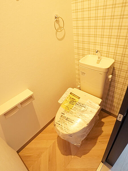 【トイレ】チェック模様が目を引く、お洒落なトイレ空間。快適にご使用いただける温水洗浄便座を搭載しています。(建物価格1770万円、建物面積100m2)
